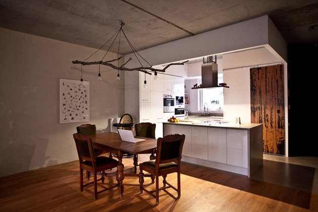 A konyha egy légtérben van a nappalival és az étkezővel, ám a burkolatok és a konyhasziget határolja./Fotó: mode:lina architekci
